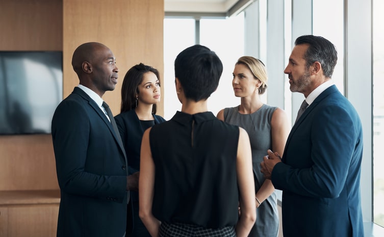 Office, management and business people in meeting talking, in conversation and discussion for strategy. Teamwork, corporate and professional men and women for planning, collaboration and partnership