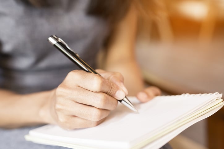 woman writing notes for her pyschedelic therapist