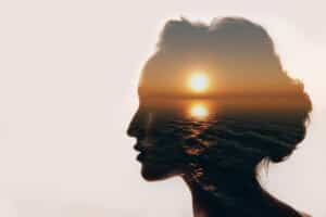A woman's profile, a sunset filled inside her profile outline